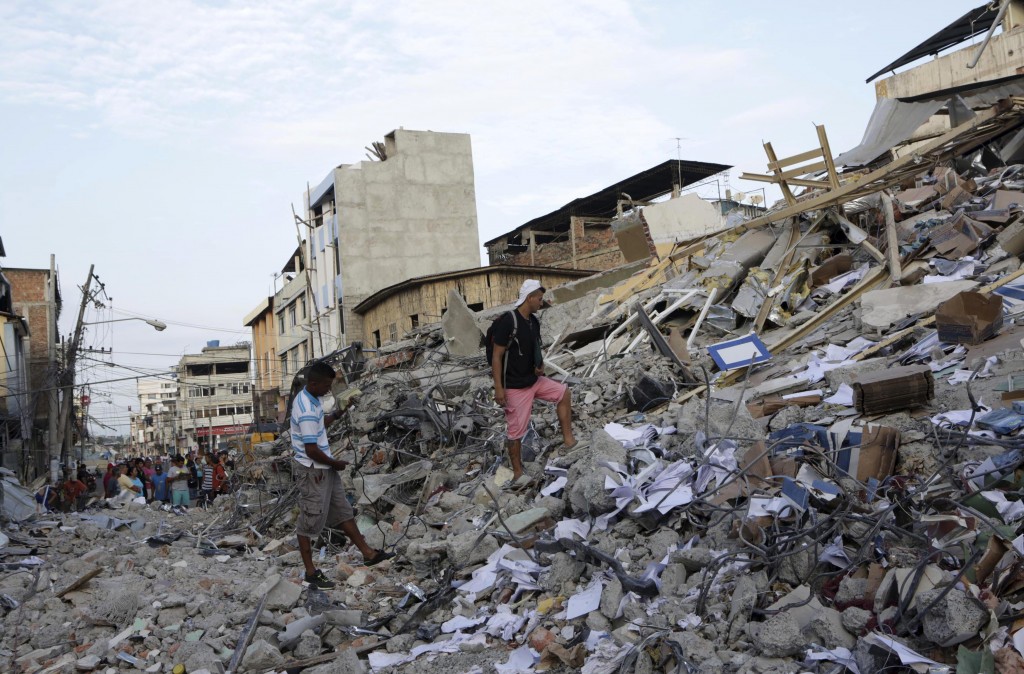 Residents walk on debris of a collapsed hotel after an earthquake struck off the Pacific coast, in Portoviejo, Ecuador, April 18, 2016. Credit: Reuters/Henry Romero