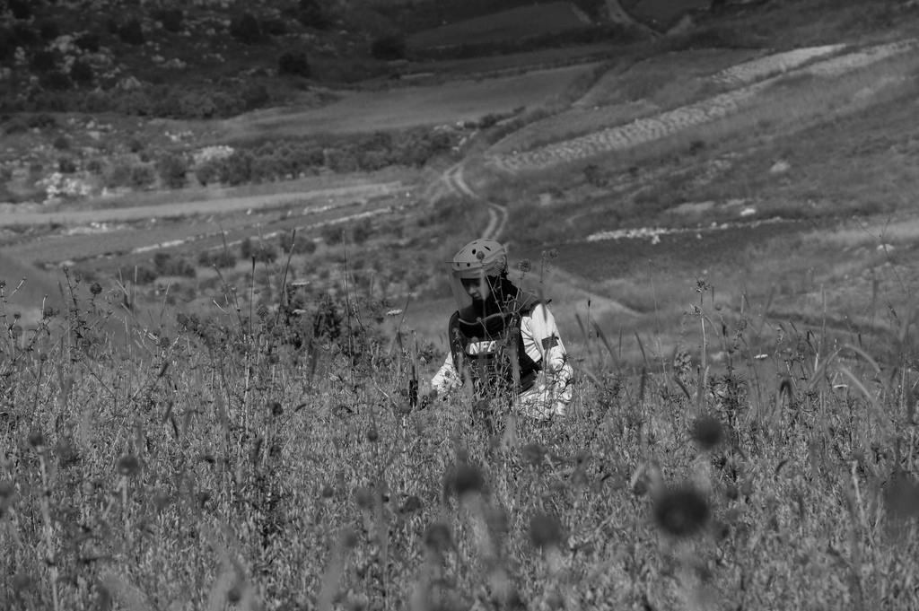 A de-miner searching for cluster bombs. Credit: Cluster Munition Coalition/Flickr CC BY 2.0