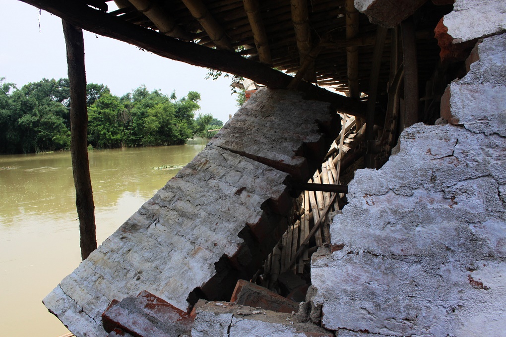 A damaged house and the flood waters of river Bagmati. Credit: Thirdpole/Prashant Ravi