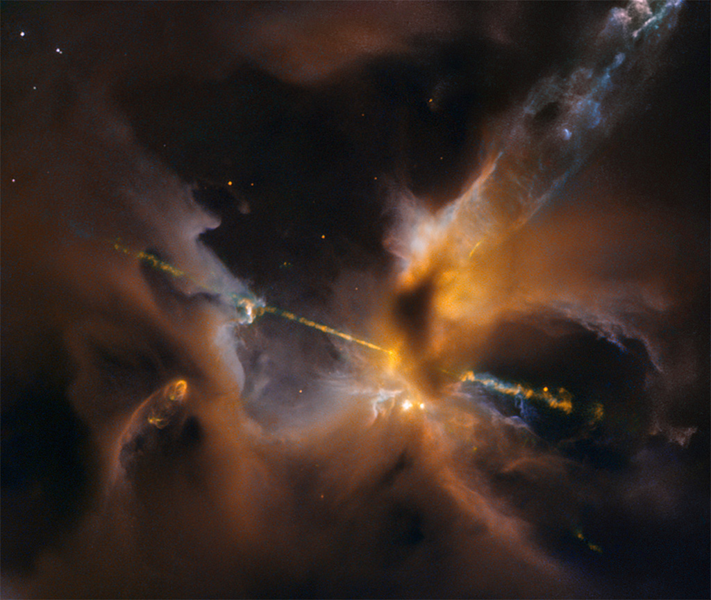 In the centre of the image, partially obscured by a dark, Jedi-like cloak of dust, a newborn star shoots twin jets out into space as a sort of birth announcement to the universe. This celestial lightsaber does not lie in a galaxy far, far away, but rather inside our home galaxy, the Milky Way. It's inside a turbulent birthing ground for new stars known as the Orion B molecular cloud complex, located 1,350 light-years away. Credit: NASA/ESA