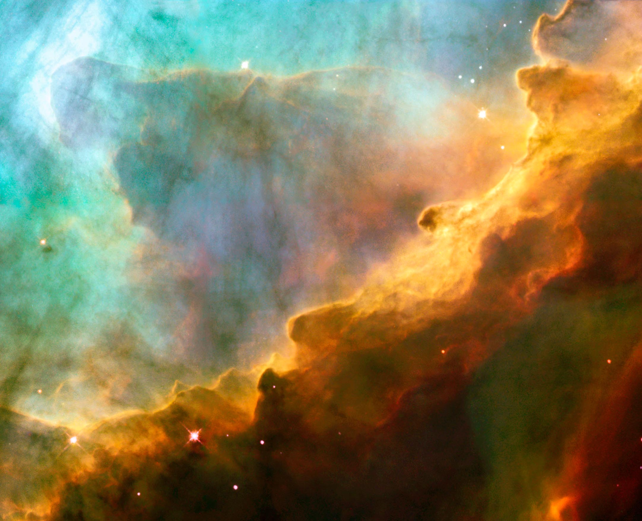 Resembling the fury of a raging sea, this image actually shows a bubbly ocean of glowing hydrogen gas and small amounts of other elements such as oxygen and sulphur. The photograph captures a small region within the Omega Nebula, located about 5,500 light-years away in the constellation Sagittarius. The wave-like patterns of gas have been sculpted and illuminated by a torrent of ultraviolet radiation from young, massive stars, which lie outside the picture to the upper left. Caption and credit: NASA, ESA and J. Hester (ASU)