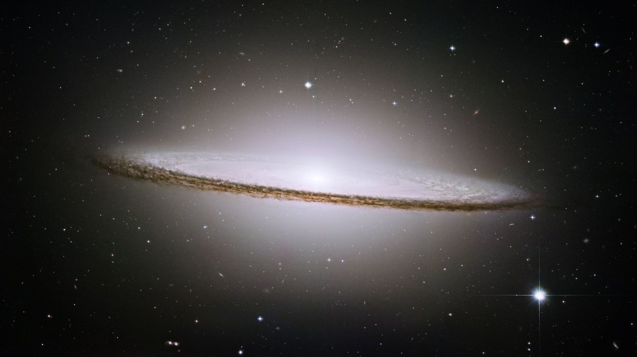 Some 28 million lightyears away is the handsome Sombrero Galaxy, captured by Hubble in an almost edge-on pose that reveals a prominent bulge toward the centre. Astronomers think there's a giant blackhole there, but they're not so sure what has given rise to the prominent ring of dust rimming the galaxy. Credit: NASA/ESA