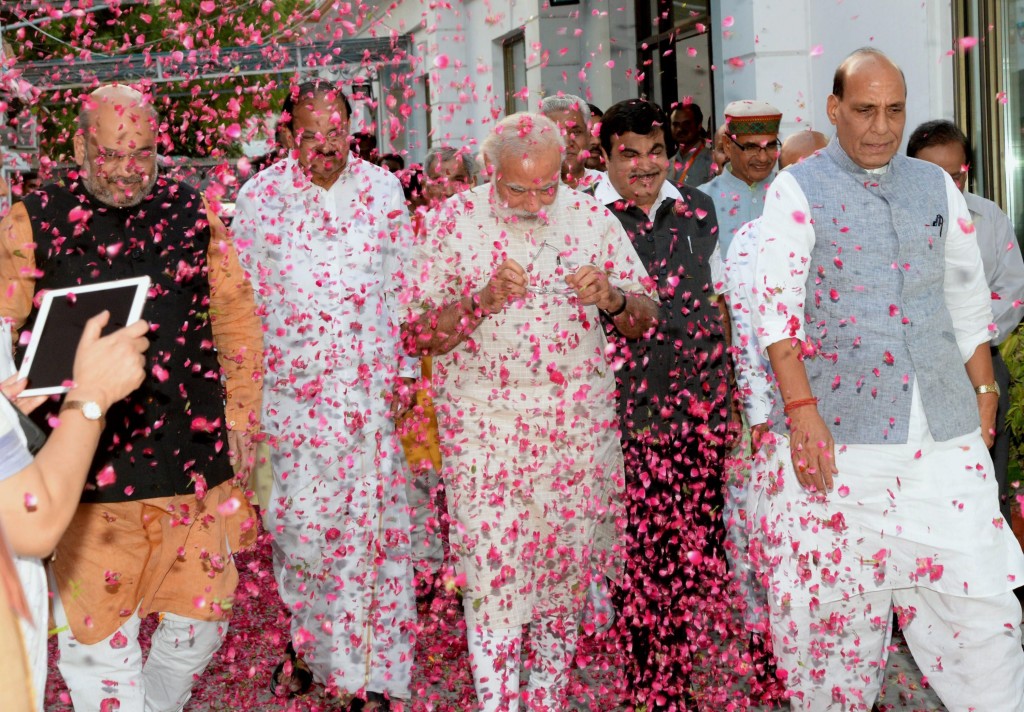 BJP workers shower flower petals on Prime Minister Narendra Modi, BJP president Amit Shah and senior leaders Rajnath Singh and M Venkaiah Naidu as they arrive at the party office in New Delhi on Thursday for a meeting after the assembly poll results. Credit: PTI/ Vijay Verma (PTI5_19_2016_000388B)