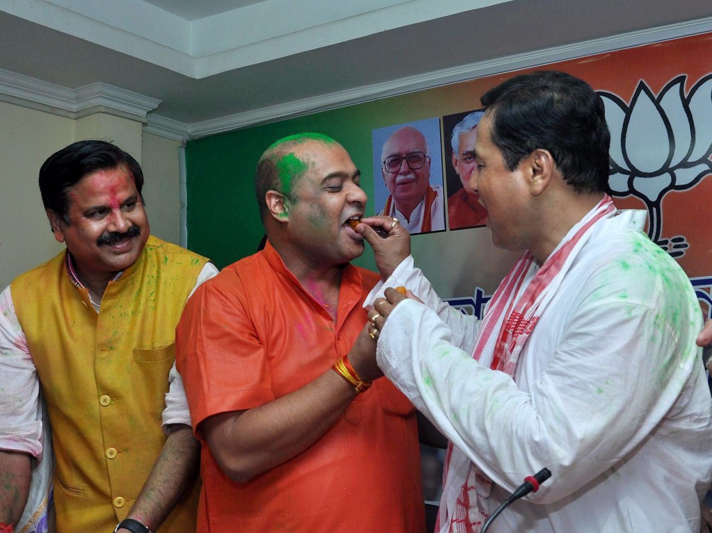 BJP chief ministerial candidate Sarbananda Sonowal exchanging sweets with party leader Himanta Biswa Sarma at a press conference after the party's win. Credit: PTI