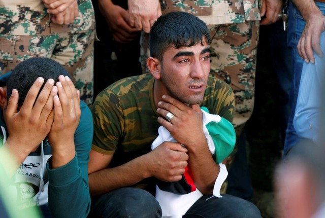 Brothers of Belal Al-Zuhbe, one of the solders killed in an attack on a border military post near a camp for Syrian refugees, cry during Al-Zuhbe's funeral at Nahleh village in the city of Jerash, north of Amman, Jordan, June 21, 2016. Credit: Reuters/Muhammad Hamed