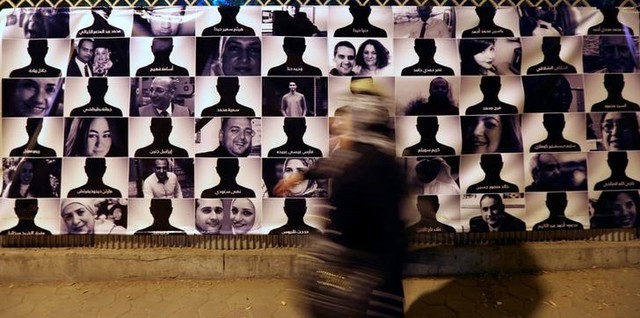 A woman passes by photos of EgyptAir flight 804 victims, at the Cairo Opera House in Cairo, Egypt May 26, 2016. Credit: Reuters/Mohamed Abd El Ghany