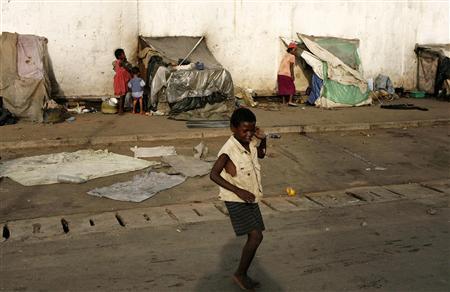 A homeless boy plays with an orange in front of makes-shift huts in Nosybe outside Antananarivo, March 19, 2009. Credit: Reuters/Siphiwe Sibeko