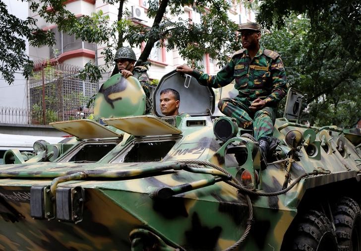 Army soldiers atop an armored military vehicle drive near the Holey Artisan restaurant after Islamist militants attacked the upscale cafe in Dhaka, Bangladesh, July 2, 2016. REUTERS/Mohammd Ponir Hossain