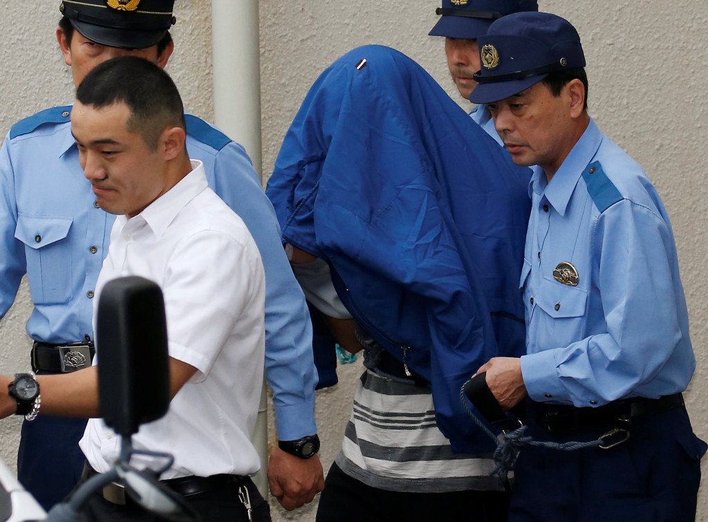 Satoshi Uematsu (C, with a jacket over his head), suspected of a deadly attack at a facility for the disabled, is escorted by police officers as he is taken from local jail to prosecutors, at Tsukui police station in Sagamihara, Kanagawa prefecture, Japan, July 27, 2016. Credits: REUTERS/Issei Kato