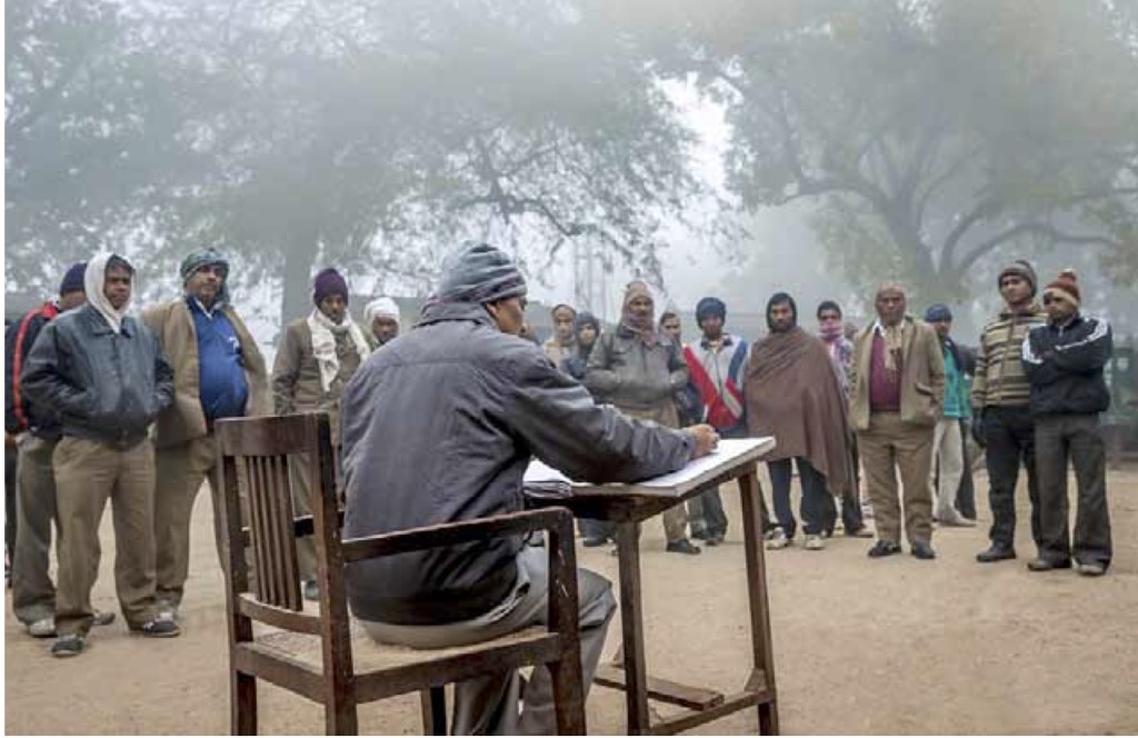 Contract workers at roll call on a winter morning. Credit: Narendra Bisht