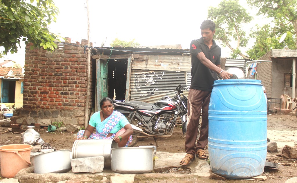 Chetan Pawar along with his mother in front of their one room house