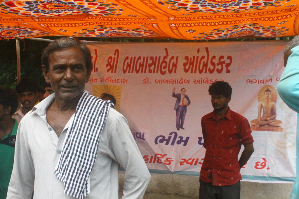A Dalit participant of the rally in front of the banner put on by locals of Beghvaa village for the public meeting. Credit: Damayantee Dhar