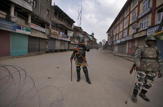 Indian security personnel stand guard along a deserted street during restrictions in Srinagar. Credit: Reuters/Danish Ismail