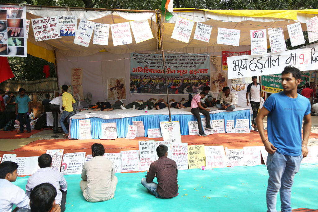 Honda workers on their ninth day of fast take rest while laying down on the stage at Jantar Mantar. Credit: Hina Fathima