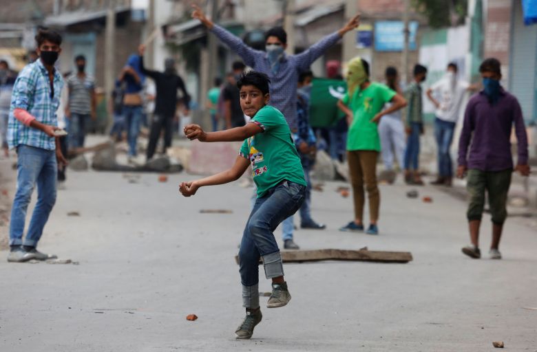 A protester throws stones towards the Indian police during a protest in Srinagar against the recent killings in Kashmir, August 9, 2016. Credit: Reuters