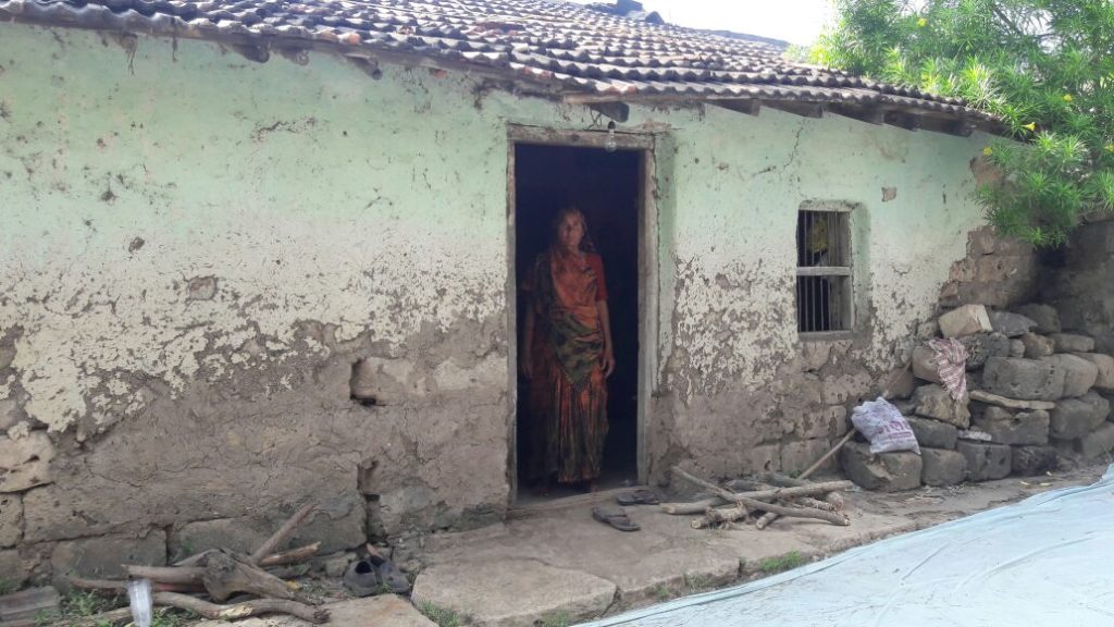 The hut where Prabhatbhai lived with his family of eight, his wife standing at the door. The picture was clicked when he was still being treated. Credit: Damayantee Dhar