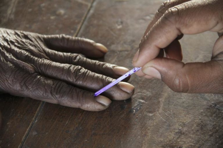 A voting official marks the finger of a voter inside a polling booth during the second phase of state elections, in Azamgarh town in the northern Indian state of Uttar Pradesh February 11, 2012. Credit: Reuters/Files