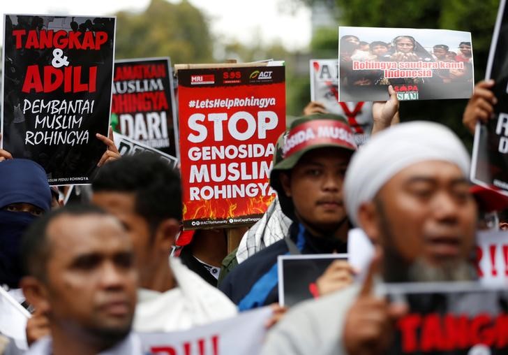 Protesters hold signs during a demonstration against what organisers say is the crackdown on ethnic Rohingya Muslims in Myanmar, outside the Myanmar embassy in Jakarta, Indonesia, November 25, 2016. The text on the poster reads,