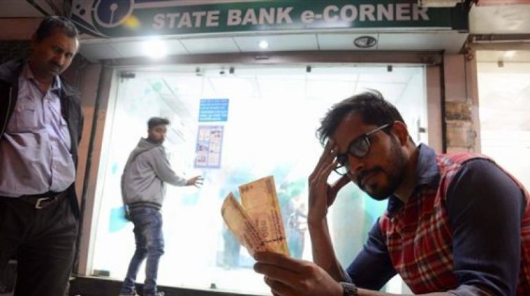 A man looks at his demonetised Rs 500 notes. Credit: PTI