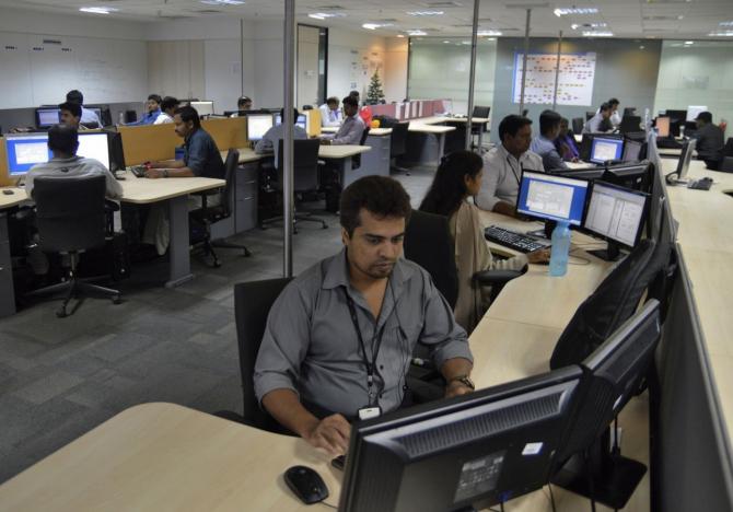 Employees of ISGN work at their stations inside the company headquarters in Bangalore. Credit: Reuters/Stringer