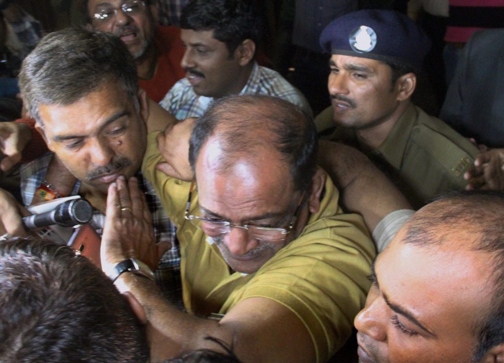 Police and Income tax officials detain land dealer Mahesh Shah, who declared Rs 13,860 crore under the IDS, in Ahmedabad on Saturday. Credit: PTI