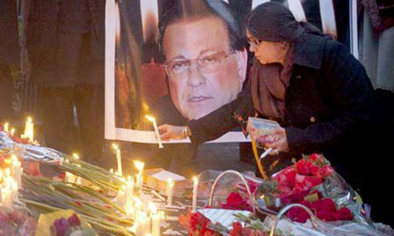 A women lighting a candle at the death anniversary of Salman Taseer. Credit: Reuters