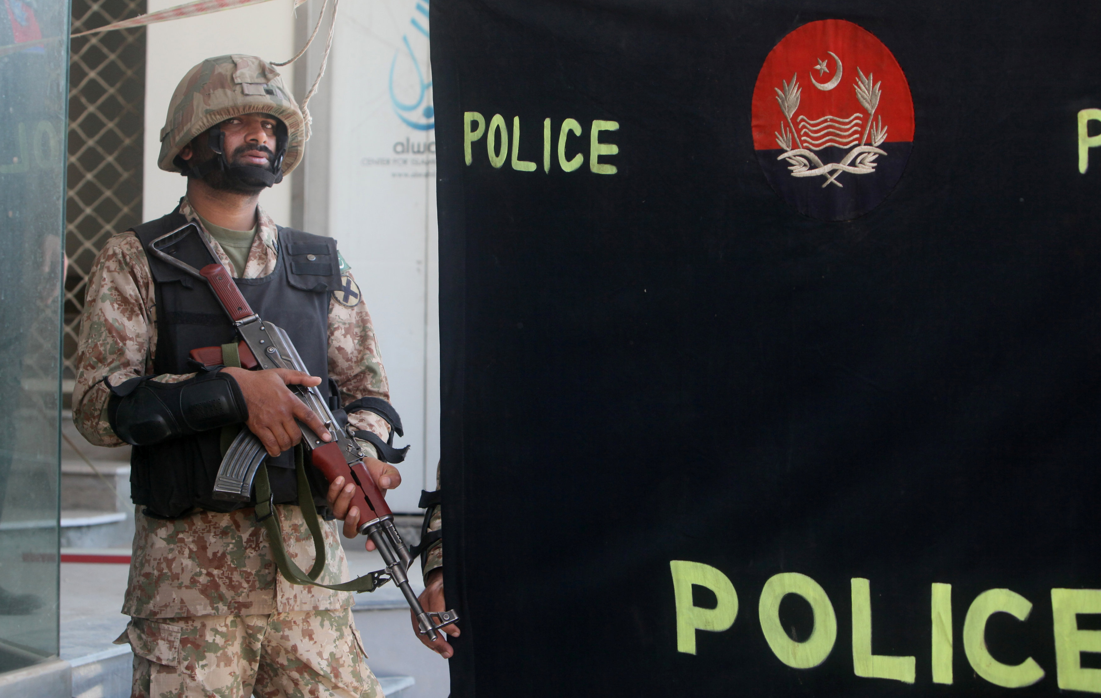 A soldier stands guard at the police screen as investigators collect evidence at the scene of a blast in a upscale neighborhood in Lahore, Pakistan February 23, 2017. Credit: REUTERS/Mohsin Raza