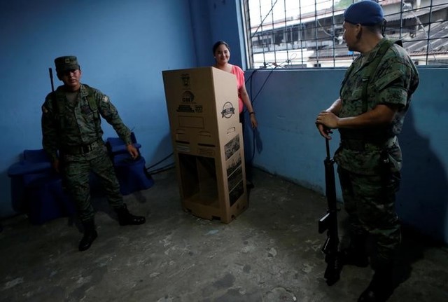 Soldiers stand guard as an election worker (C) prepares ballot boxes during the presidential election in a public school, used as a polling station, in Guayaquil, Ecuador February 19, 2017. Credit: Reuters