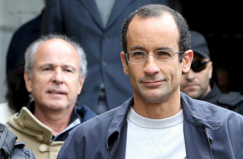 Marcelo Odebrecht (R), the head of Latin America's largest engineering and construction company Odebrecht SA, and Otavio Marques Azevedo (L), CEO of Brazil's second largest builder Andrade Gutierrez, are escorted by federal police officers as they leave the Institute of Forensic Science in Curitiba, Brazil, June 20, 2015. Credit: Reuters