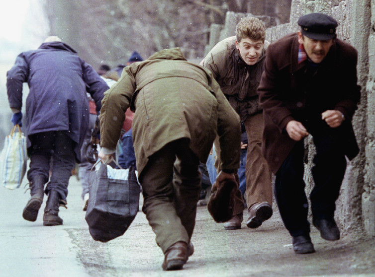 People run for cover as they pass an area of heavy Serb sniper fire in the besieged Sarajevo, Bosnia, 1993. Credit: Reuters/Chris Helgren