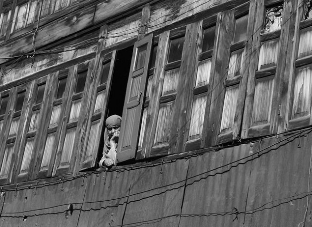 A woman looks out of the window at a mental health facility. Credit: Shazia Yousuf/IPS/Files