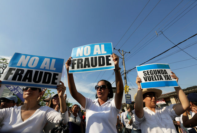 People hold signs reading