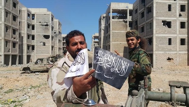 Members of the East Libyan forces shows flags of Islamist-led rivals after capturing their final holdout in the southwest of Benghazi, Libya, March 18, 2017. Credit: Reuters/Stringer