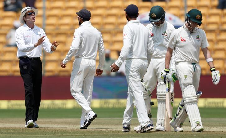 Cricket - India v Australia - Second Test cricket match - M .Chinnaswamy Stadium, Bengaluru, India - 07/03/17. India's captain Virat Kohli (2nd L) speaks to the umpire as Australia's captain Steven Smith (R) walks off the ground after being dismissed. Credit: Reuters/Danish Siddiqui