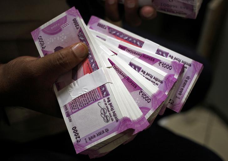 A cashier displays the new 2000 Indian rupee banknotes inside a bank in Jammu, November 15, 2016. Credit:Mukesh Gupta/Reuters/File photo