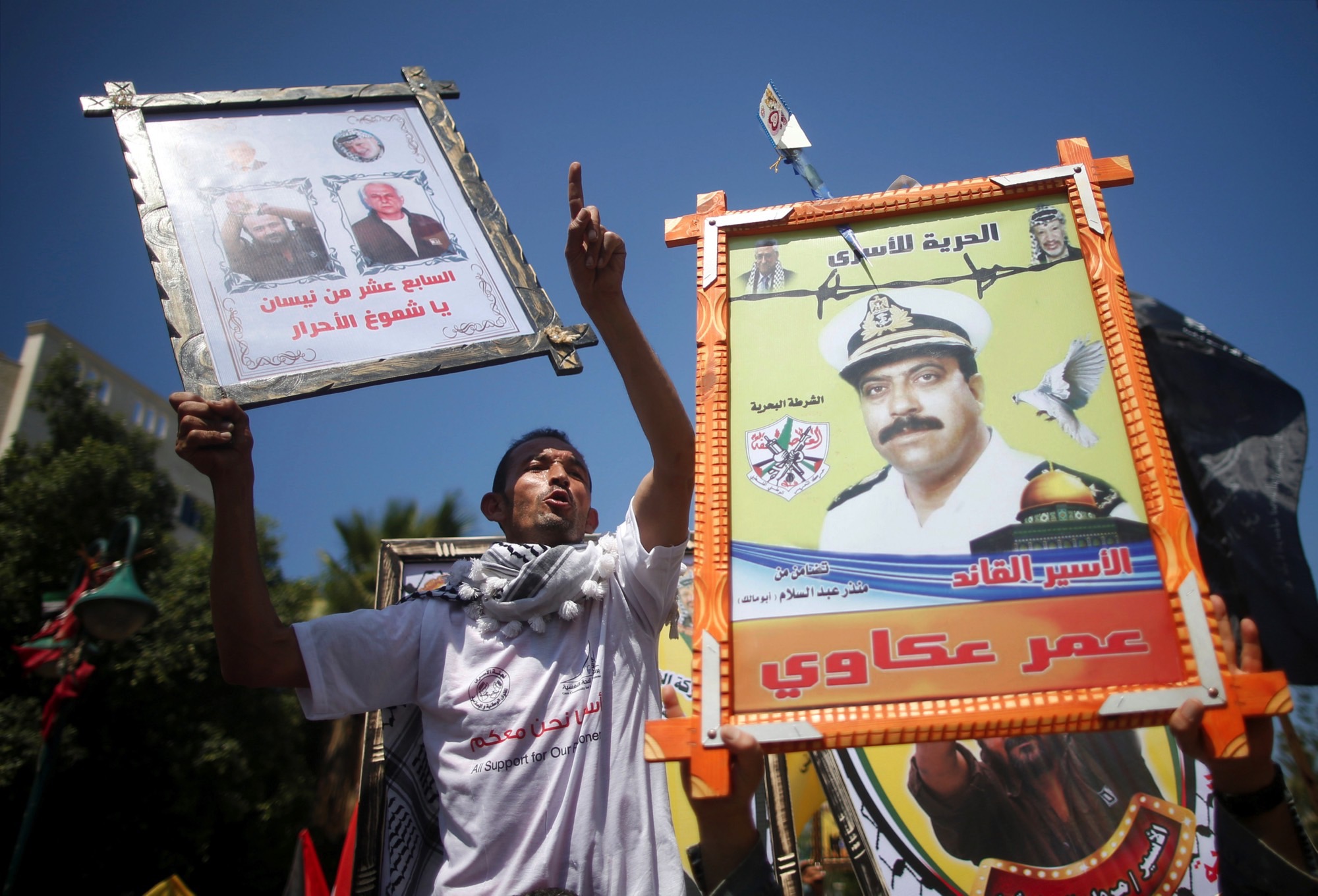 Demonstrators hold pictures of jailed Palestinians during a rally in support of Palestinian prisoners on hunger strike in Israeli jails, in Gaza City April 17, 2017. Credit: Reuters/Mohammed Salem