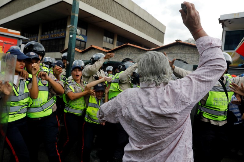 An elderly opposition supporter confronts riot security forces while rallying against President Nicolas Maduro in Caracas, Venezuela, May 12, 2017. Credit: Reuters/Carlos Garcia Rawlins