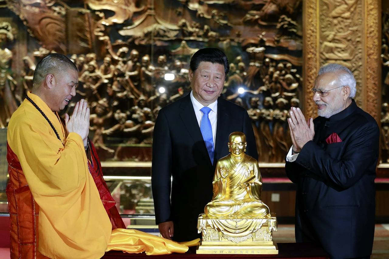 Chinese President Xi Jinping (C) looks on as Indian Prime Minister Narendra Modi (R) receives a golden Buddha statue from an abbot of the Dacien Buddhist Temple in Xi’an, Shaanxi province, China, May 14, 2015. Credit: Reuters