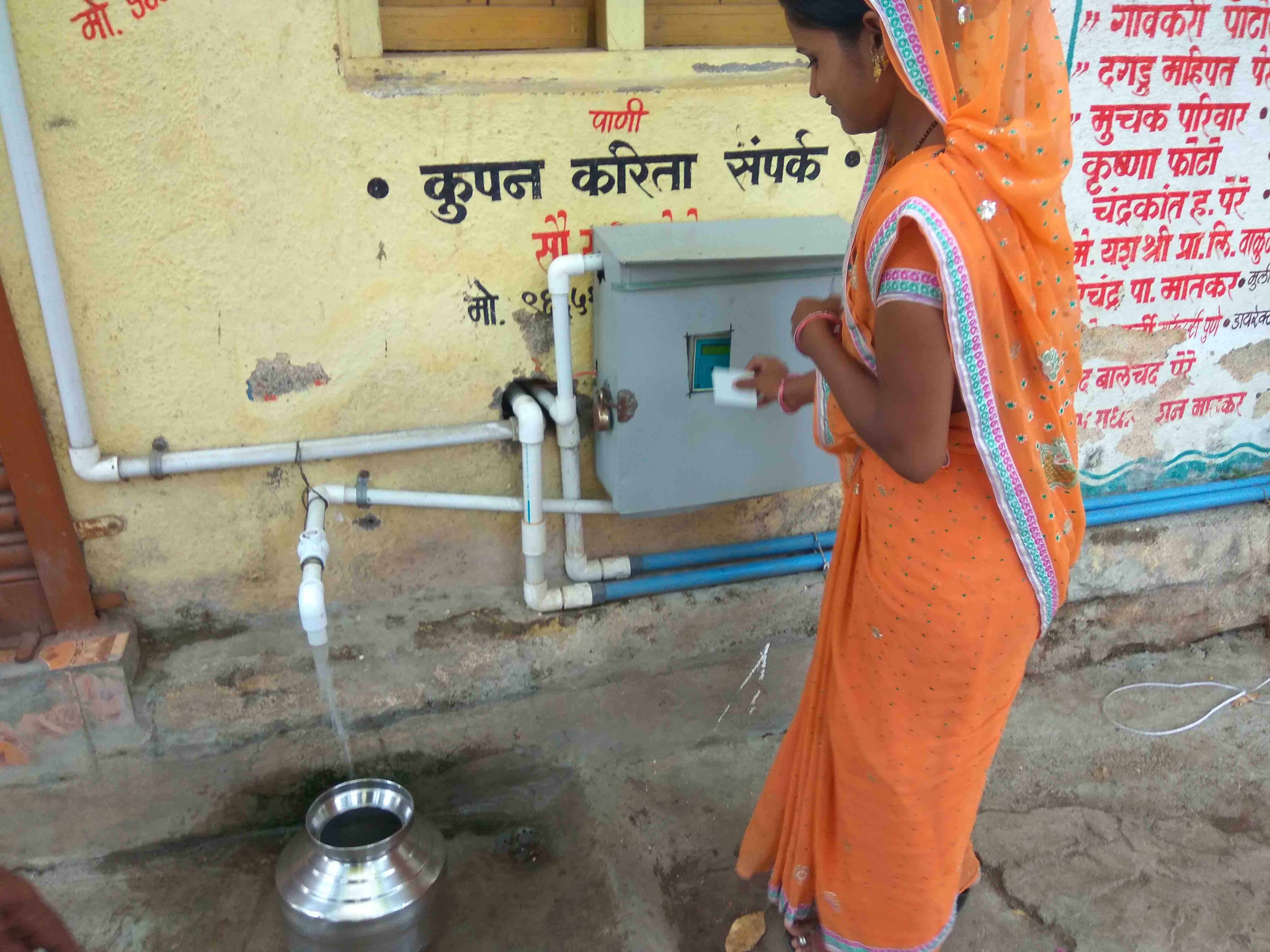 A resident of Patoda village, outside Aurangabad, uses her ‘ATM card’ to fill a pot with purified drinking water. Credit: Raghu Karnad