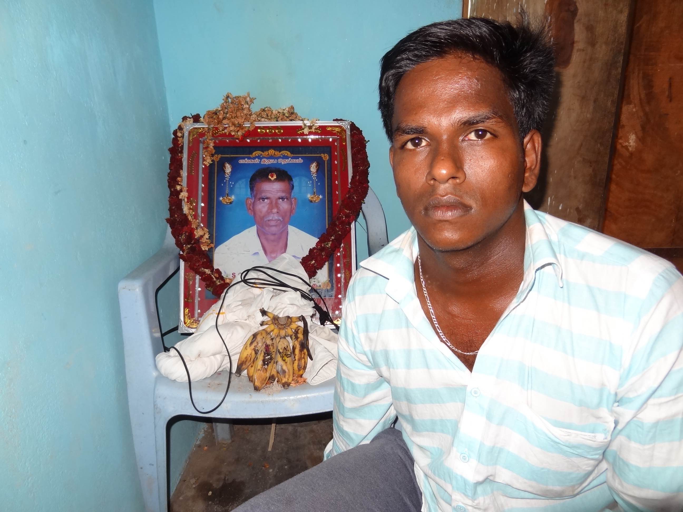 Karti with his father's photograph at their home. Credit: Jaideep Hardikar