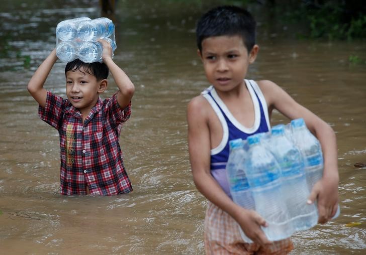 Boys carry water bottles distributed by an aid organisation during the flood in Kyaikto township, Mon state, Myanmar July 22, 2017. Credit: Reuters/Soe Zeya Tun