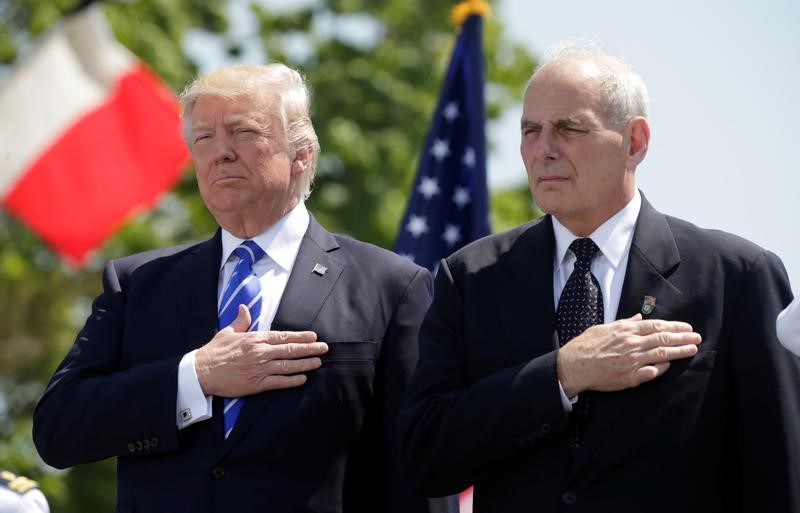 U.S. President Donald Trump (L) and U.S. Department of Homeland Security Secretary John Kelly hold their hands over their hearts for the U.S. National Anthem as they attend the Coast Guard Academy commencement ceremonies where Trump addressed the graduating class in New London, Connecticut, U.S., May 17, 2017. Credit: Reuters/Kevin Lamarque/File Photo