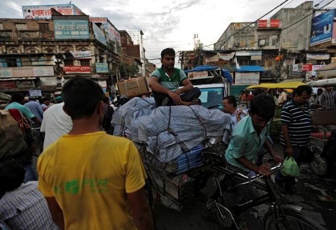 A man sits on top of a rickshaw loaded with card boxes at a wholesale market in the old quarter of Delhi, India, August 2, 2016. Credit: Reuters/Adnan Abidi/file photo