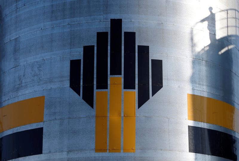 The shadow of a worker is seen next to a logo of Russia's Rosneft oil company at the central processing facility of the Rosneft-owned Priobskoye oil field outside the West Siberian city of Nefteyugansk, Russia, August 4, 2016. Credit: Reuters/Sergei Karpukhin/File Photo