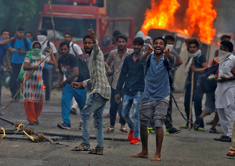 People react during violence in Panchkula, India, August 25, 2017. Credit: Reuters/Cathal McNaughton