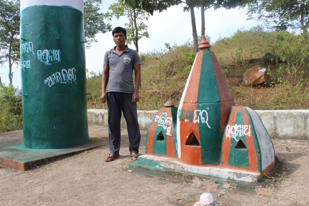 Subhas Jhodia standing near the tombstones of Abhilash Jhodia, Damodar Jhodia and Raghunath Jhodia, the three killed in police firing during a peaceful dharna against mining at Maikanch, Kashipur. Subhas is the younger brother of Abhilash. Credit: Abhijit Mohanty