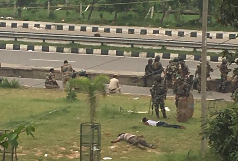 The police stand near bodies of two men killed in Panchkula following a violent riot by supporters of Gurmeet Ram Rahim Singh. Credit: Special Arrangement