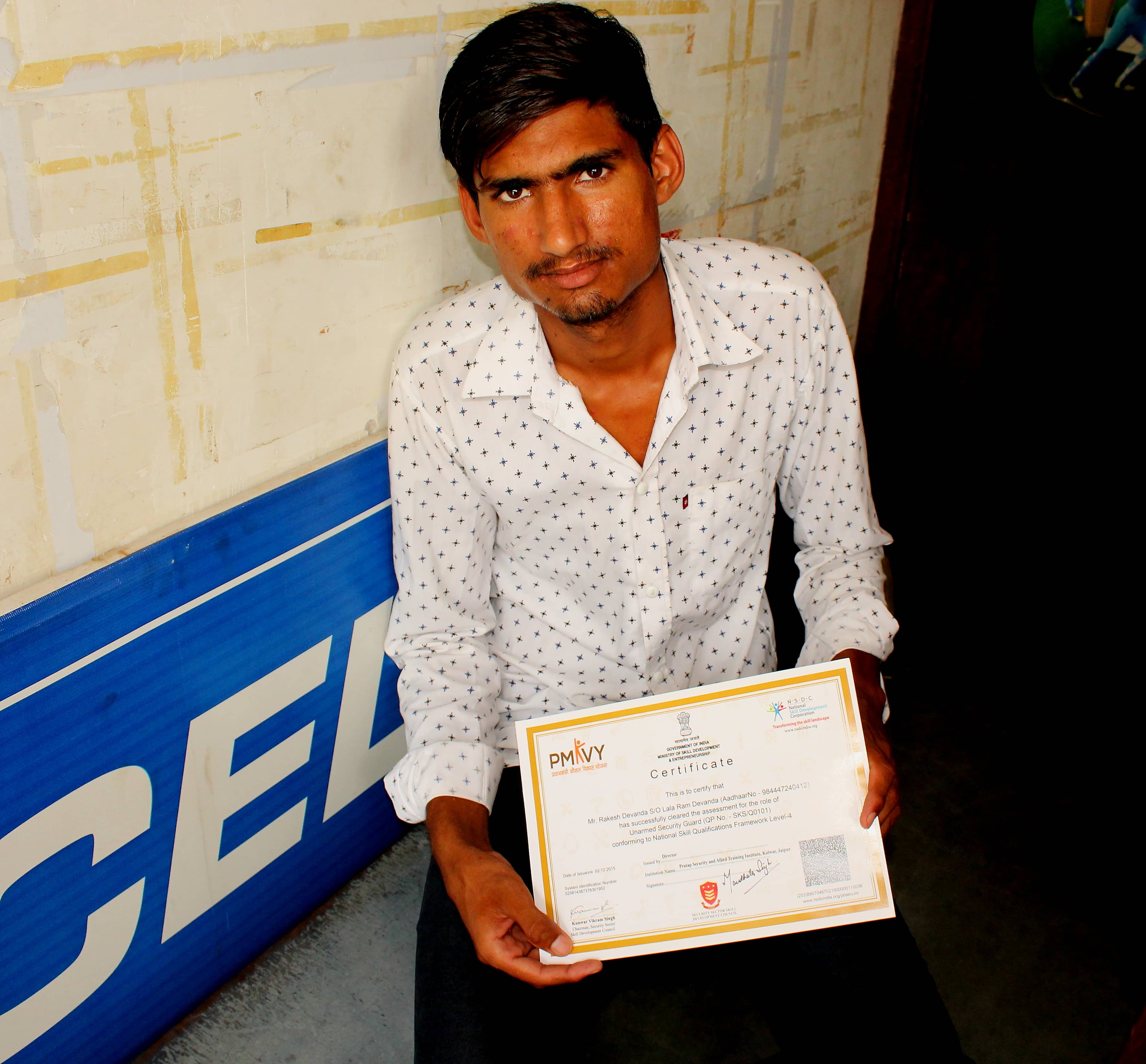 Rakesh holding the Unarmed Security Guard training certificate under PMKVY in Kalwar village. Credit: Shruti Jain