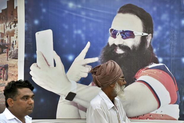 File photo of a poster of Dera chief Gurmeet Ram Rahim Singh, convicted of rape on Friday. Credit: PTI
