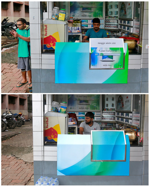A combination photo shows a man holding his mobile phone as he lights a cigarette next to a Marlboro advertisement pasted on a vendor's stall in a marketplace in Mumbai, India, July 14, 2017 and a vendor selling cigarettes inside the same stall, August 18, 2017. The ad on the front of the stall was removed after a Reuters investigation was published on July 18, which cited Indian federal health ministry officials as saying that the displays violated the country’s anti-smoking laws. Credit: Reuters/Danish Siddiqui